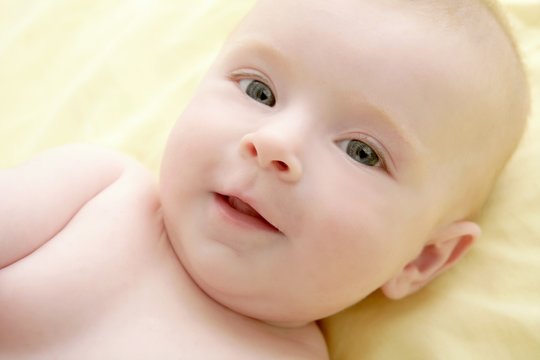Blond little baby laying on bed portrait