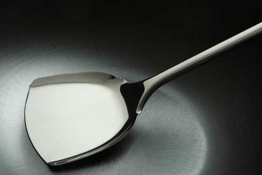 stainless spatula in fry pan  on a white background