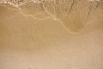 Fototapeta na wymiar Wave of water on sand beach. Natual summer background.