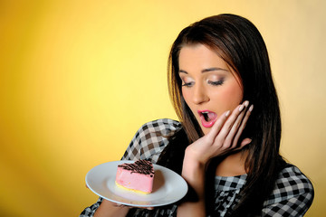 young beautiful girl eating small sweet cake