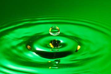 Naklejka na ściany i meble tranquility conceptual. green droplet splash in a water