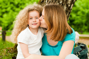 mother kissing her daughter