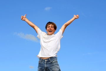 happy teenager jumping on blue sky background