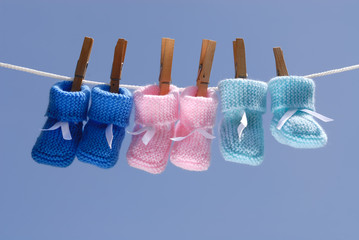 trois pair de chaussons de bébé sur fil à linge © aldegonde le compte