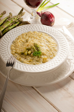 asparagus rice with fork on dish and red wine