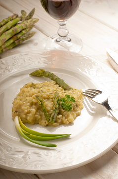 asparagus rice with fork over dish and red wine