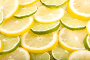 Gordijnen Close-up van gesneden citroenen en limoenen © James Insogna
