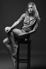Black and white shot of girl sits on chair