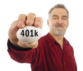 Mature man holds a white nest egg with 401k on it.