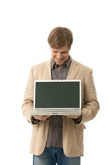Young man holding laptop with blank screen
