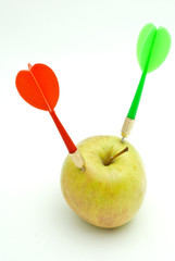 Darts and apple on a white
