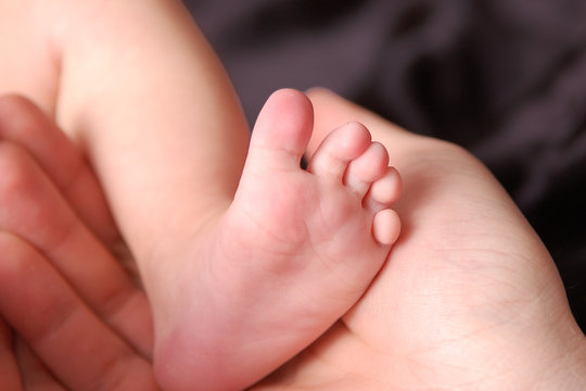 Baby foot in mother's hand