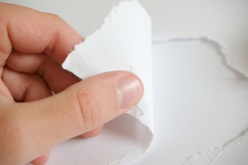 Hand mit aufgerissenem Papier