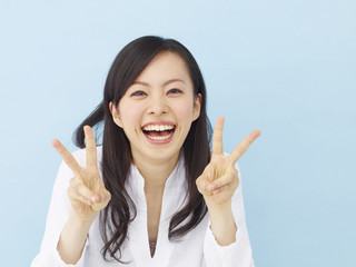 女性・ブルーバック・ピースサイン