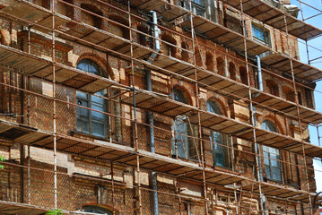 scaffolds round an old brick building