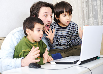 Family in living room with laptop smiling