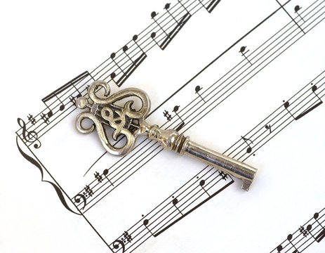 Old figural key with treble clef & lire on sheet music