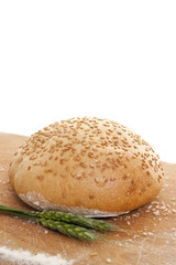 loaf of bread on a wooden base with young wheat