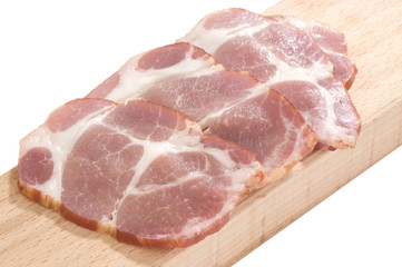 Sliced cooked pork neck on a cutting board isolated