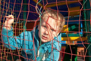 one little boy behind bars in the playground