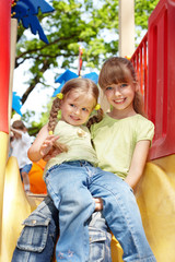 Children on slide outdoor in park.