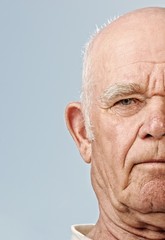 Elderly man's face over blue background