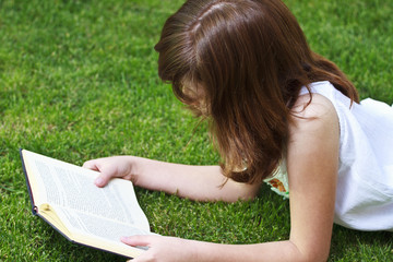 Young beautiful girl reading a book outdoor