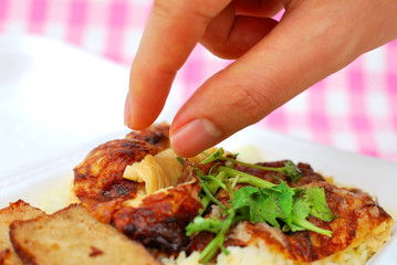 Finger reaching for roasted chicken