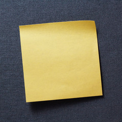 A blank yellow memo on grey texture