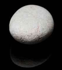Fototapeta na wymiar A white sand stone on black background