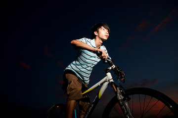 Obraz na płótnie Canvas young asian man with bike