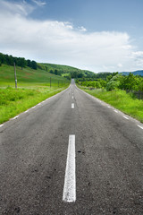 Obraz premium Empty road between trees
