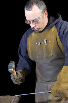blacksmith bending a wrought iron rail