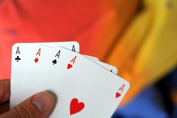 hand holding four aces