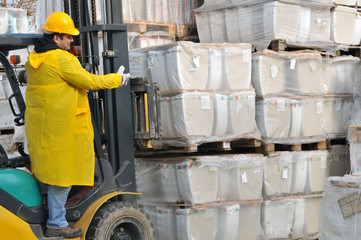 Forklift operator working at warehouse.
