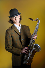 young man  in bowler hat holding saxophone