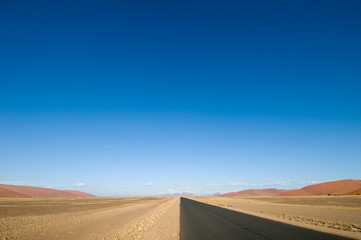 Fototapeta na wymiar Long straight empty desert road, Namibia