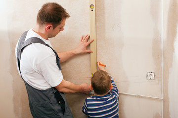 Vater und Sohn vermessen Tockenbau Wand