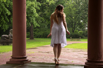 Eine Frau im weißen Sommerkleid bei Regenwetter