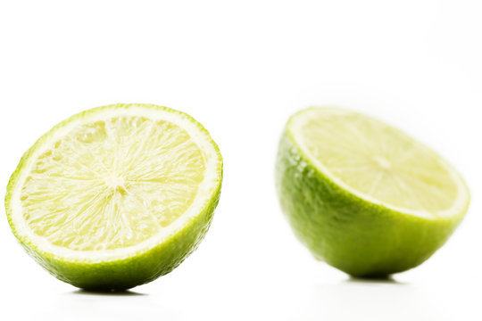 zwei halbe limonen auf weißem hintergrund