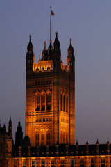 illuminated tower with flag of Houses of Parliament