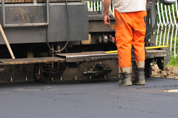 Fototapeta na wymiar Robotników drogowych przed układarki asfaltu