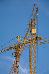 Fototapeta na wymiar two construction cranes with sky as a background
