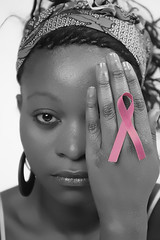 Concepto de cancer de pecho, retrato de mujer cubriéndose un ojo con la mano, lazo rosa