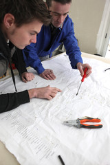 Ouvriers devant plan de chantier