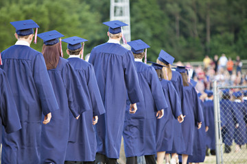 Line of school graduates in blue caps and gowns