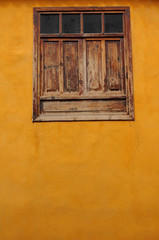 Wood window on orange colored wall
