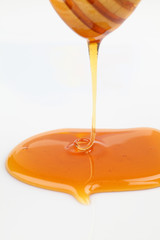 Close up of pouring honey on white background
