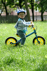 child learning to ride on a first bike without pedals