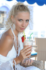 Young woman drinking cocktail in a cafe outdoors